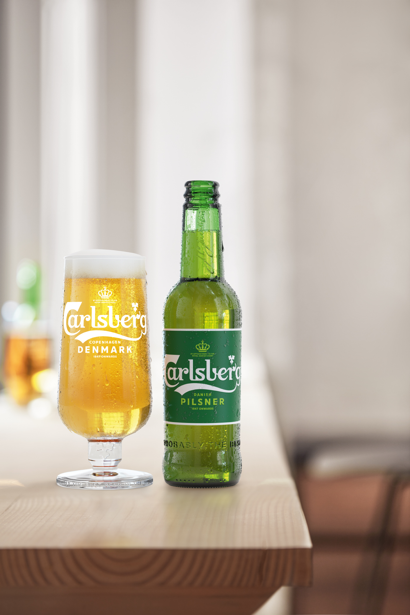 Bottle of Carlsberg beer sitting next to glass of beer