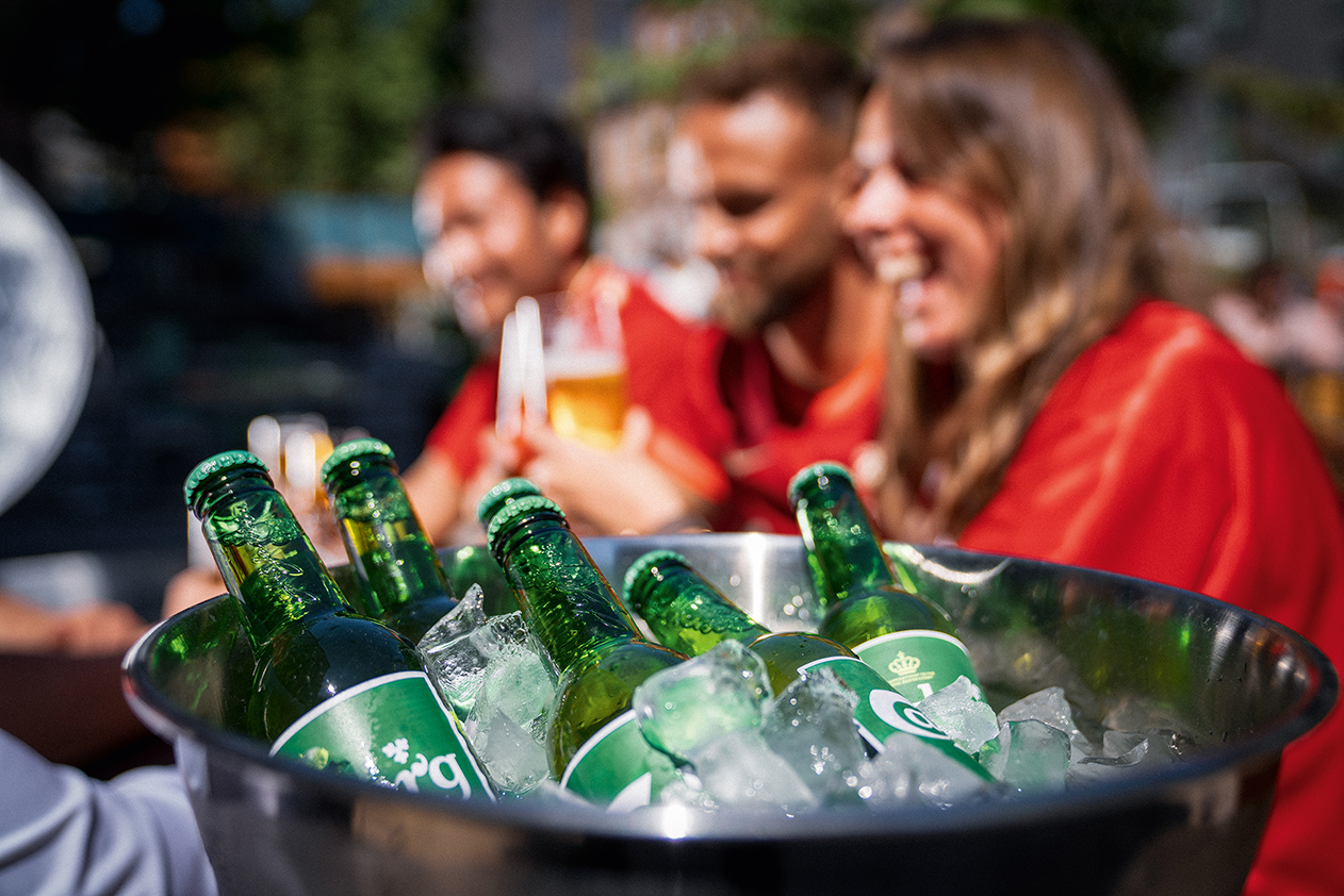 Ice bucket with Carlsberg beer and people in background