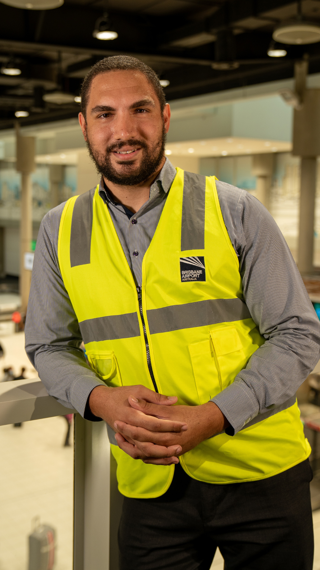 Man smiling standing in airport with hi-vis