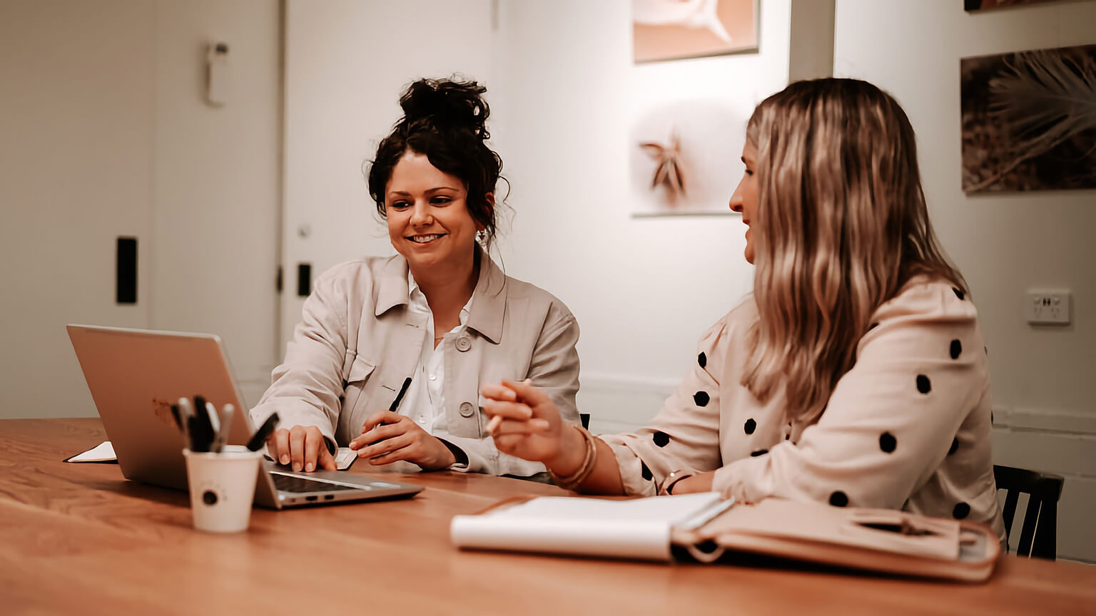 Two content marketers sitting at a table discussing strategy